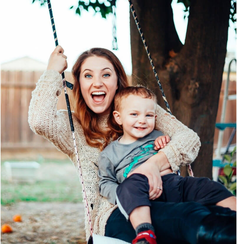 A woman smiling while holding her son after a dentist appointment in Colleyville, TX